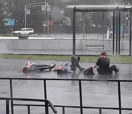 Время в райчихинске. Лежать под дождем на асфальте. Девушка лежит на асфальте под дождем. Лужа на асфальте под дождем. Лежит под дождем на асфальте Мем.